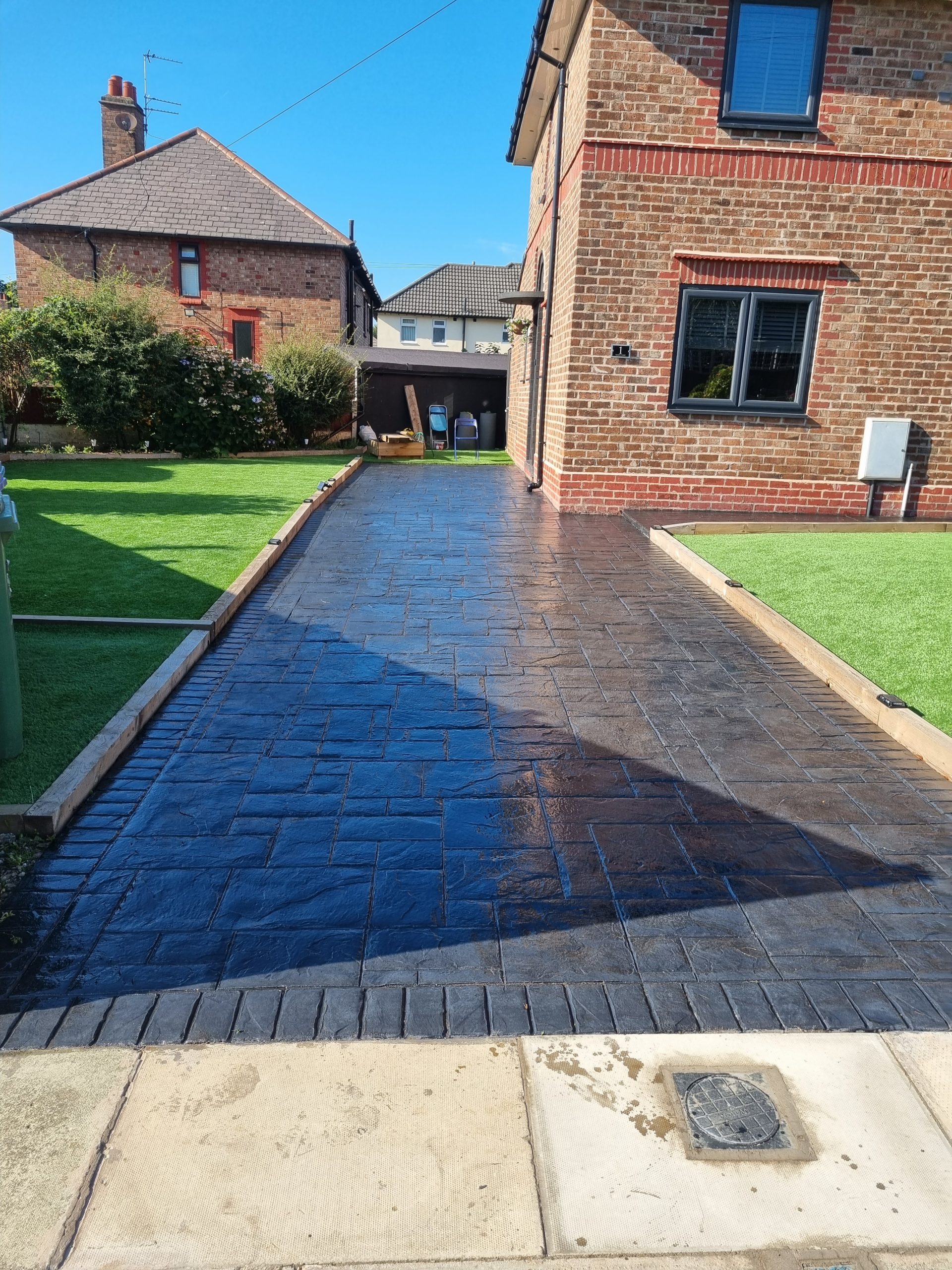 Dark grey patterned poured concrete driveway